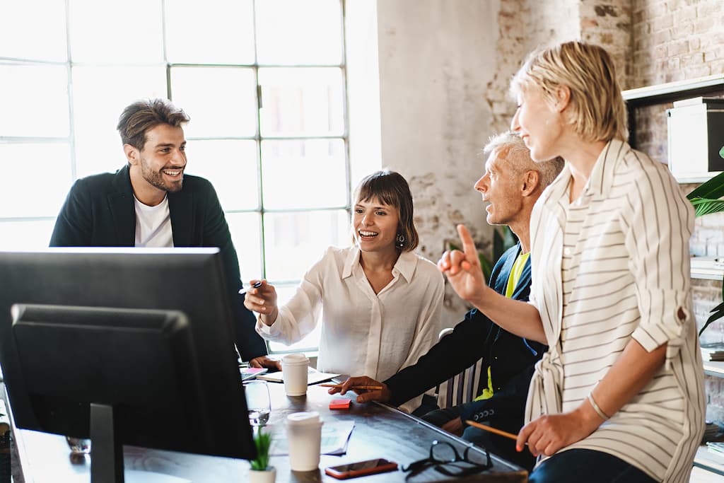 Employees sharing laptop in office